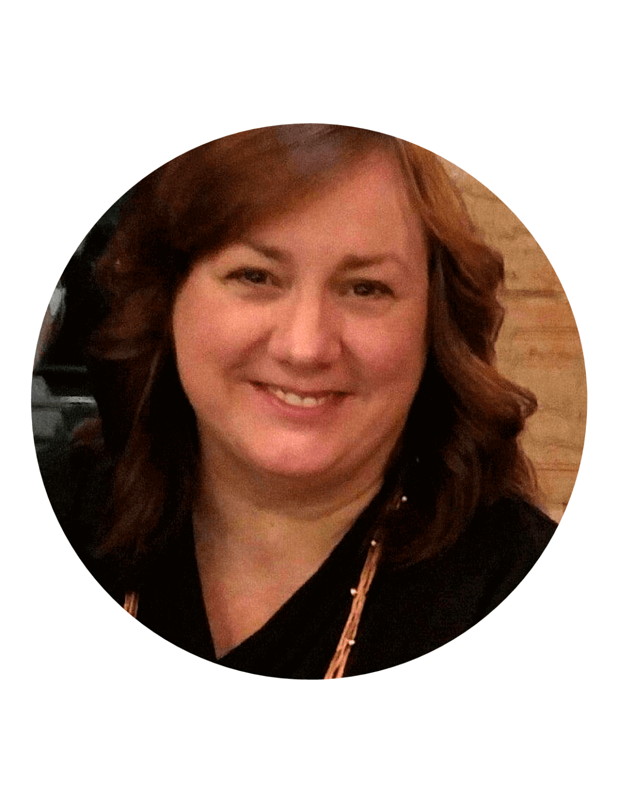 Smiling woman with wavy auburn hair in a black top.