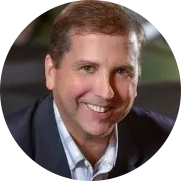 Smiling man in a suit jacket and collared shirt.