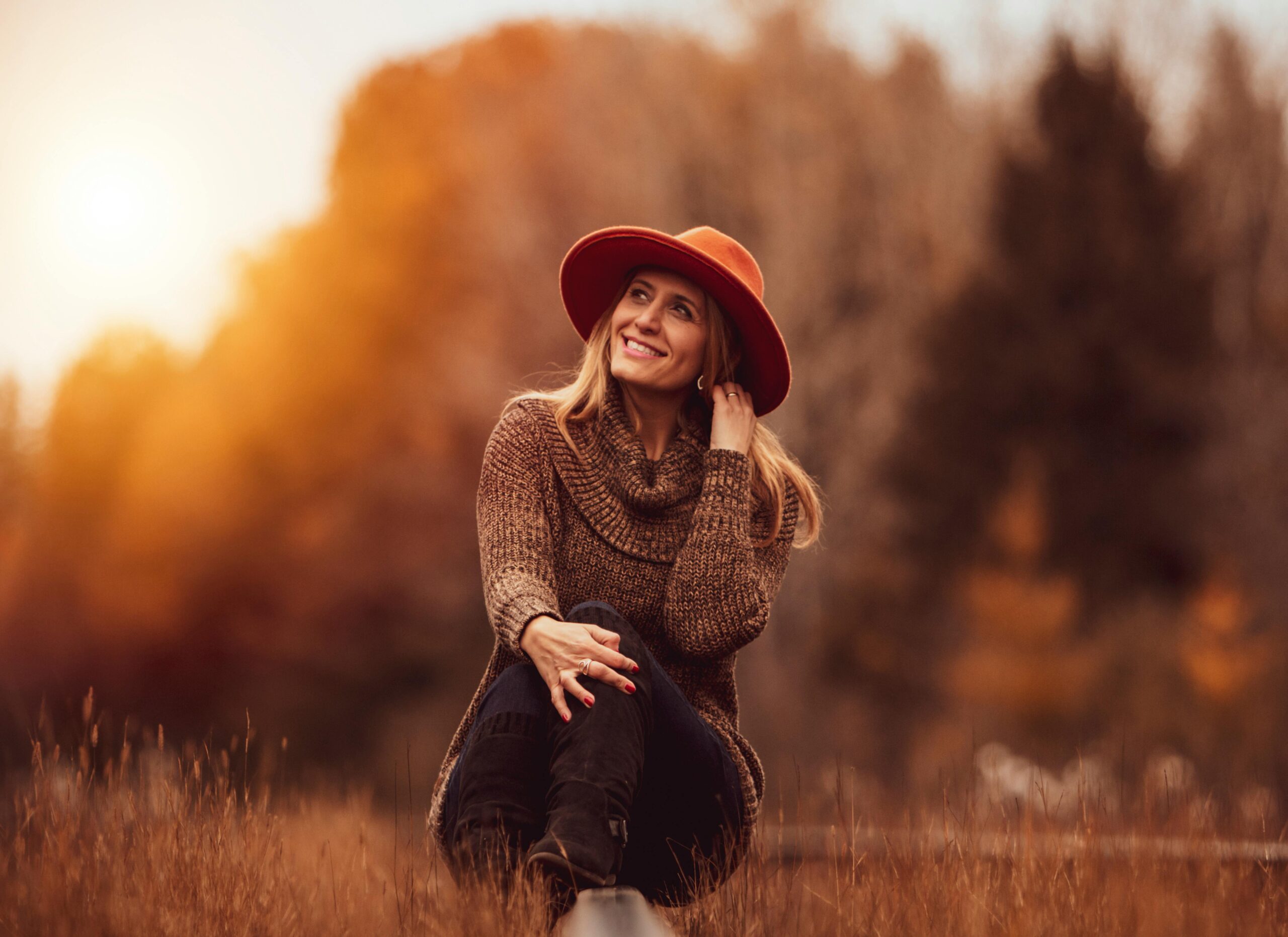 Woman in a red hat enjoying autumn outdoors.